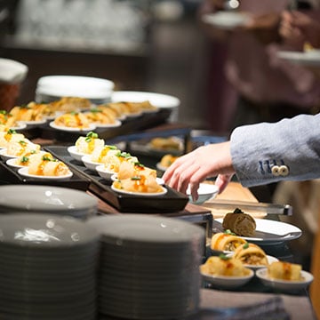 How early should food and beverage planning be done to host an event?
