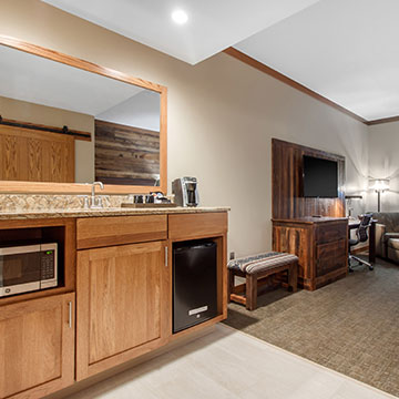 What amenities are available in the guestrooms of Norfolk Lodge & Suites